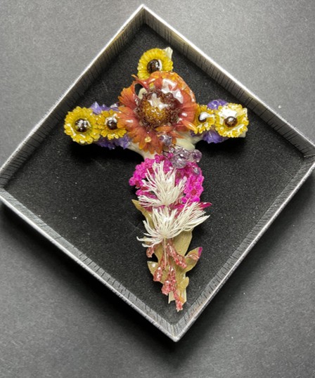 Handcrafted cross formed from colorful preserved flowers